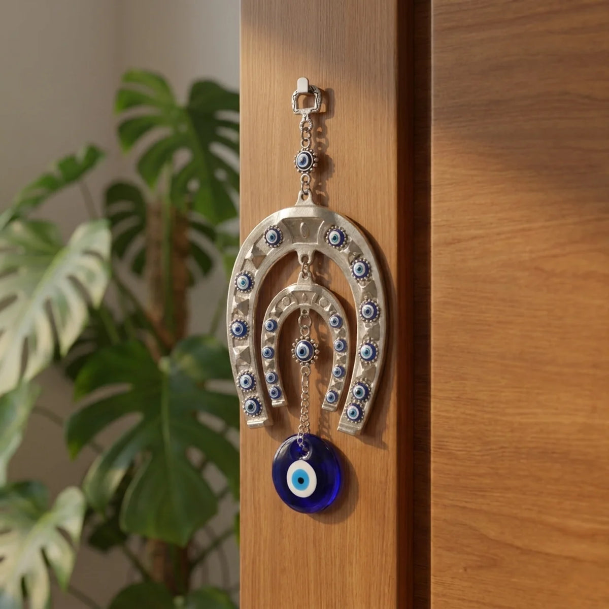 Herradura protectora de acero con ojo turco colgada detrás de la puerta