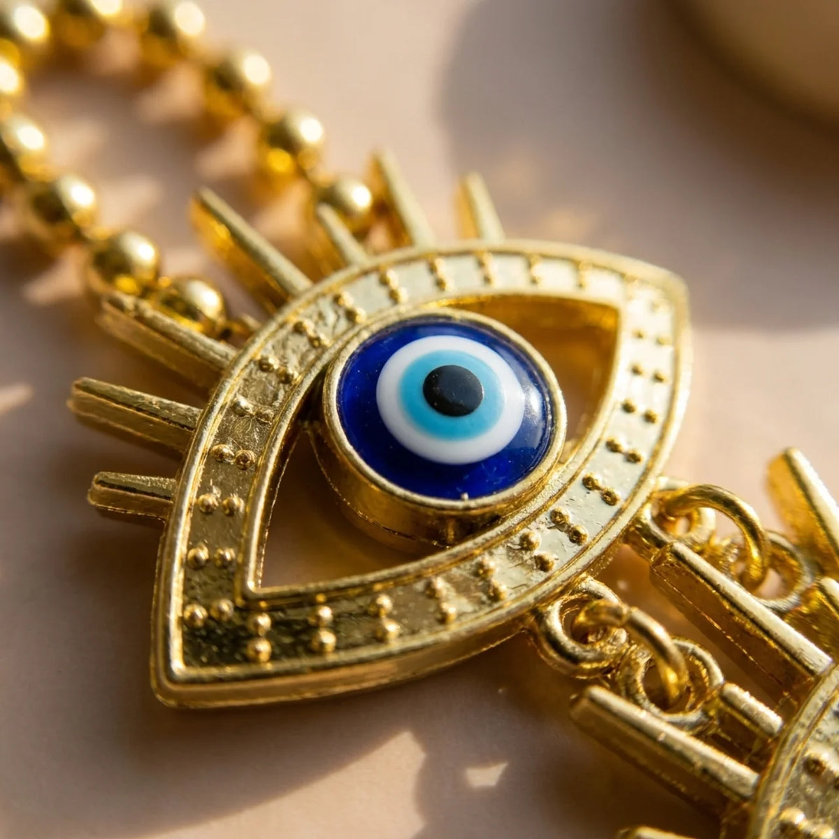 Detalle del ojo turco de acrílico dorado de la cadena superior