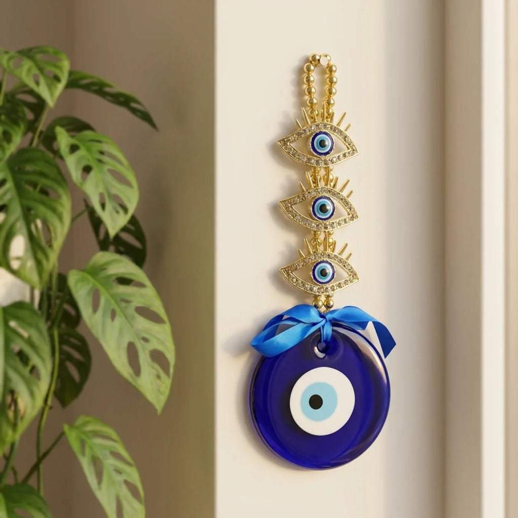 Ojo turco de vidrio azul con cadena dorada colgado en el ingreso del hogar