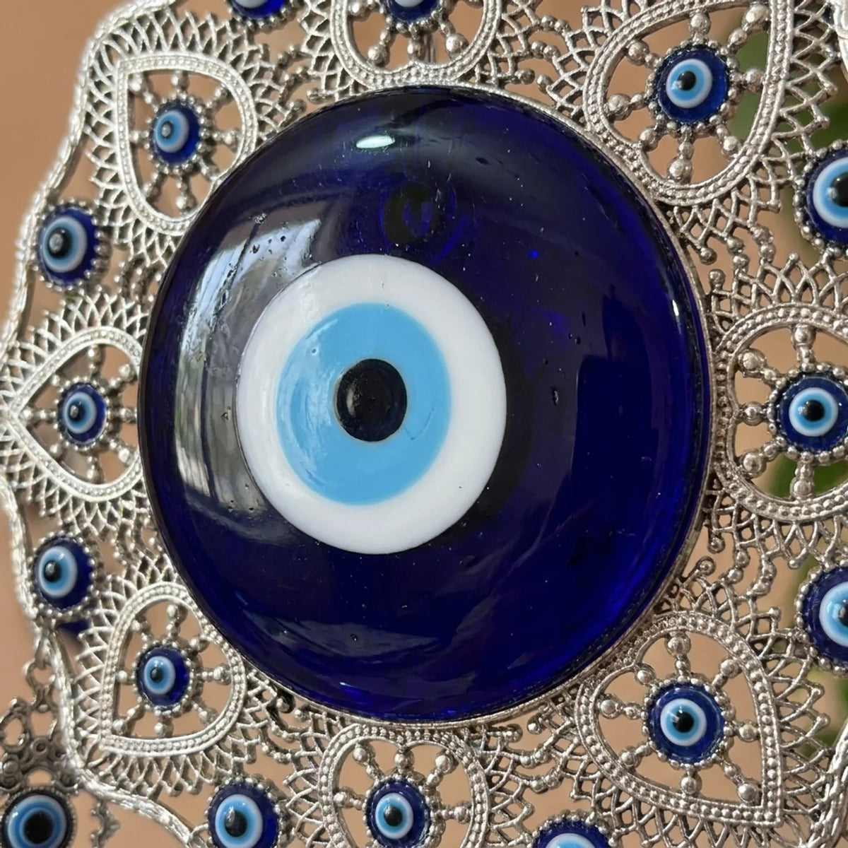 Detalle del ojo turco de vidrio azul en el centro del amuleto de acero